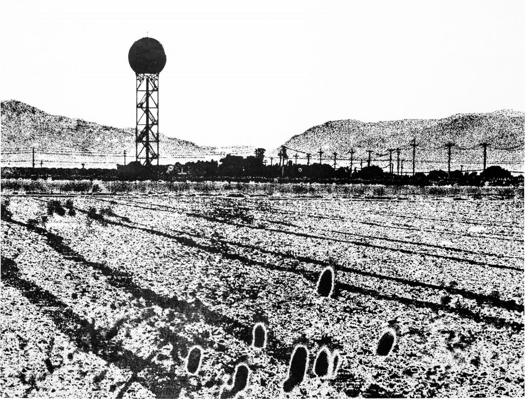 Black and white relief print of a landscape with furrows in the foreground, a doppler radar tower and power lines in the midground, and a mountain gap in the background.